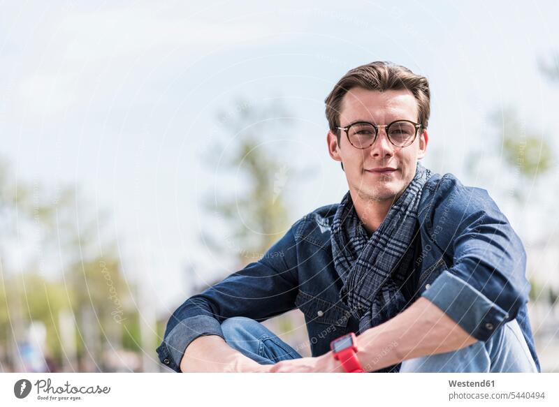 Portrait of confident young man outdoors smiling smile glasses specs Eye Glasses spectacles Eyeglasses men males portrait portraits Adults grown-ups grownups