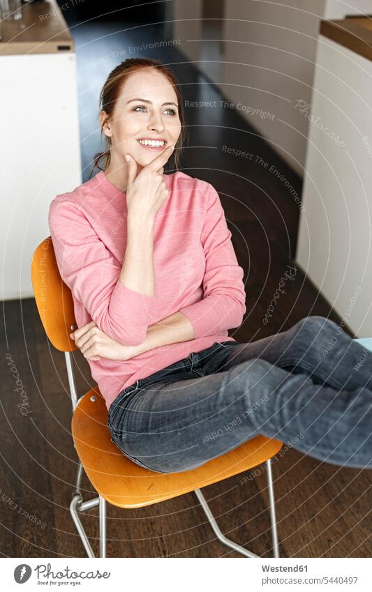 Portrait of smiling young woman sitting on wooden chair at home Seated chairs females women portrait portraits smile Adults grown-ups grownups adult people