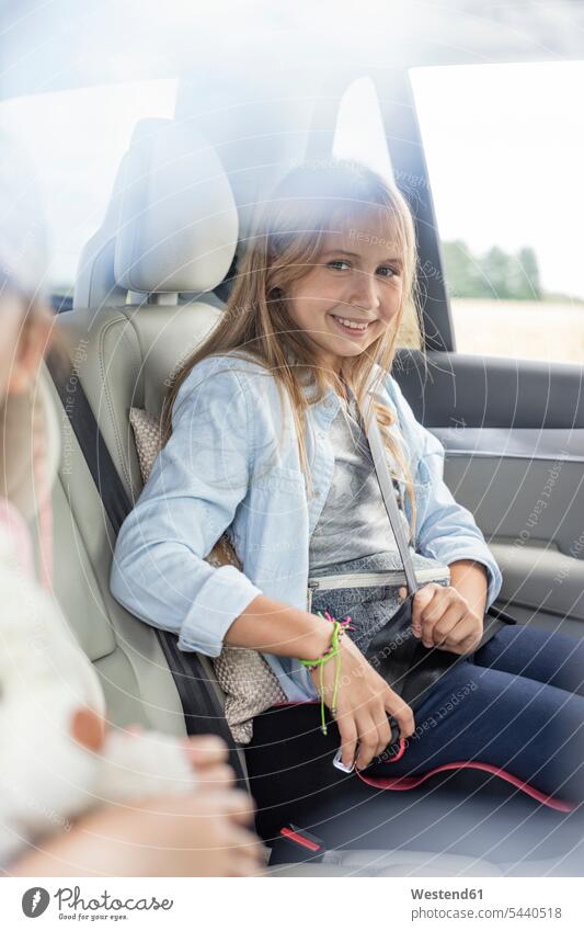 Girl sitting in car, fastening seat belt Seated automobile Auto cars motorcars Automobiles smiling smile vacation Holidays Road Trip roadtrip Road-Trip