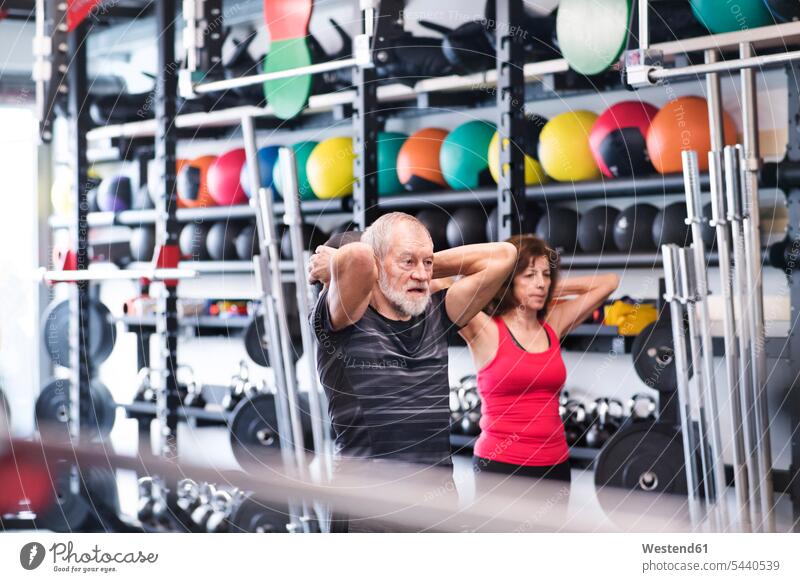 Senior mand and woman in gym exercising with medicine balls exercise training practising senior adults seniors old gyms Health Club Adults grown-ups grownups