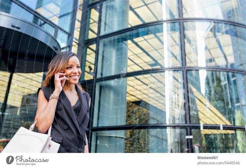Smiling woman on the phone outside office building in the city smiling smile mobile phone mobiles mobile phones Cellphone cell phone cell phones call