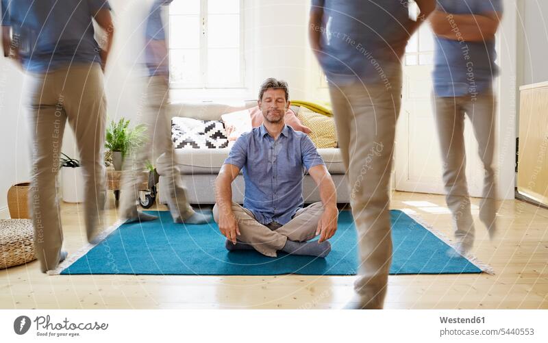 Man sitting on ground, meditating Seated Yoga floor floors man men males relaxation relaxed relaxing home at home comfortable meditation meditations Adults