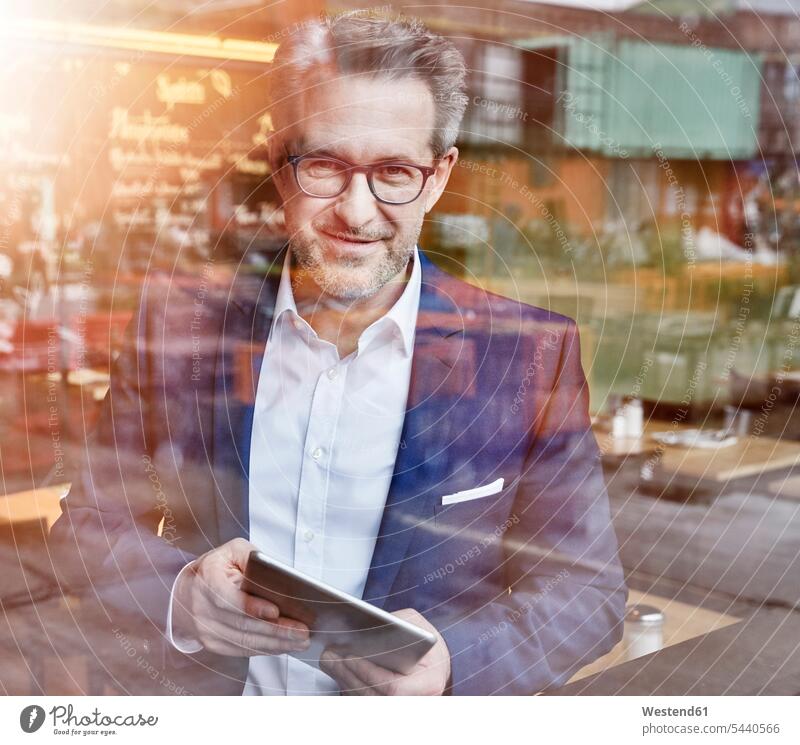 Confident mature businessman with tablet looking out of window windows smiling smile digitizer Tablet Computer Tablet PC Tablet Computers iPad Digital Tablet