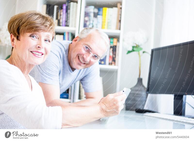 Senior couple at desk with digital tablet smiling smile twosomes partnership couples digitizer Tablet Computer Tablet PC Tablet Computers iPad Digital Tablet