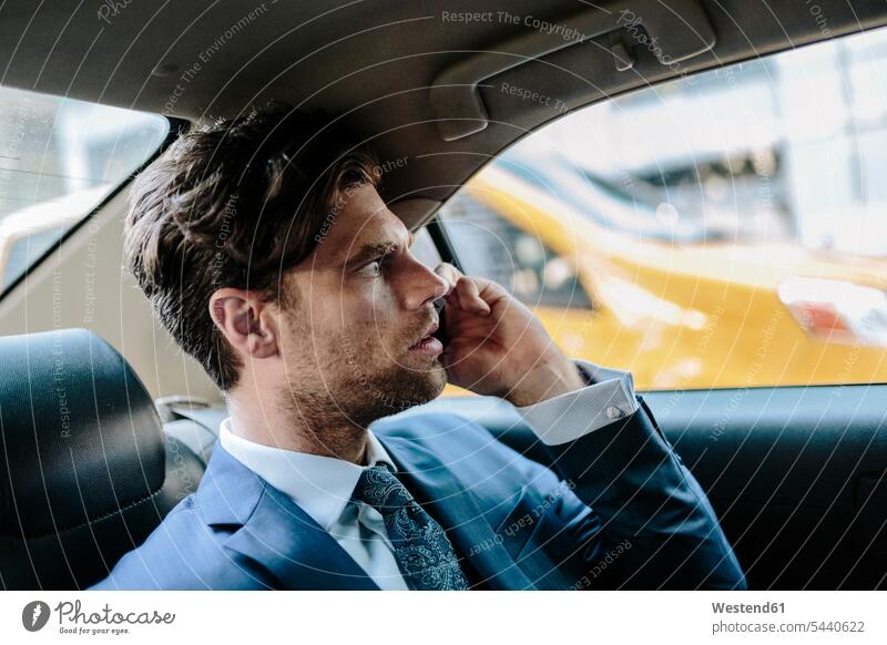 Businessman sitting in taxi, using smart phone attractive beautiful pretty good-looking Attractiveness Handsome on the phone call telephoning On The Telephone