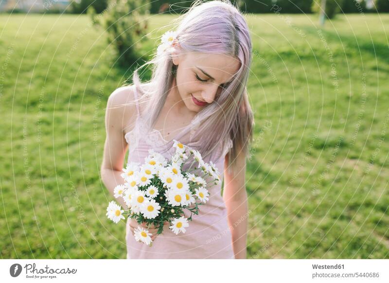 Smiling woman with bunch of daisies on a meadow Daisy Bellis perennis Daisy Flower Daisies females women portrait portraits Flowers Adults grown-ups grownups