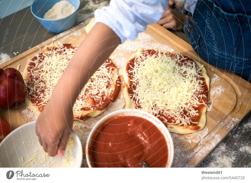 Girl in kitchen learning how to bake pizza, sprinkling cheese domestic kitchen kitchens baking Pizza Pizzas sprinkle Cheese girl females girls Food foods