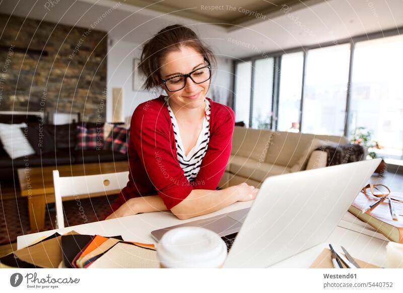 Portrait of smiling sitting at desk at home freelancer freelancing woman females women Adults grown-ups grownups adult people persons human being humans