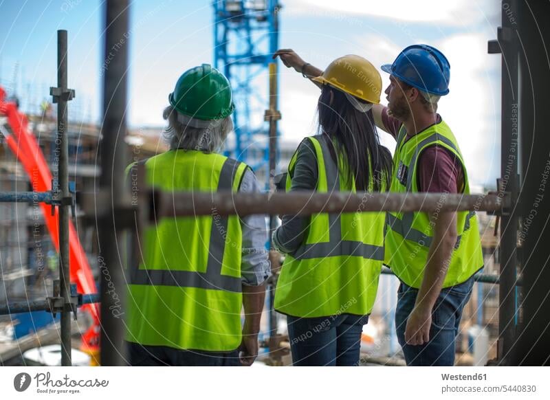 Construction worker talking to man and woman on a construction site construction worker builders working At Work Building Site sites Building Sites