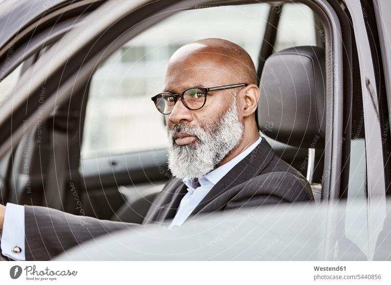 Businessman driving a car on the move on the way on the go on the road Business man Businessmen Business men automobile Auto cars motorcars Automobiles