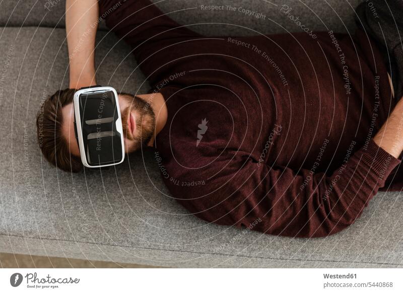 Man lying on the couch using Virtual Reality Glasses VR glasses Virtual-Reality Glasses virtual reality headset vr headset vr goggles