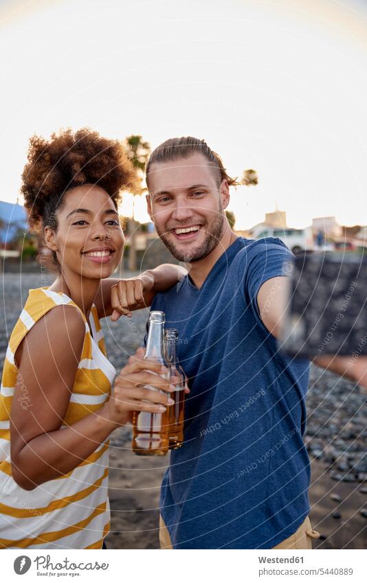 Two friends with beer bottles taking selfie on the beach beaches Selfie Selfies portrait portraits friendship evening in the evening Smartphone iPhone