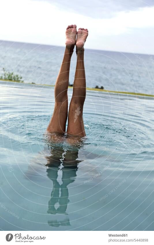 Legs of woman diving in swimming pool pools swimming pools leg legs human leg human legs females women people persons human being humans human beings Adults