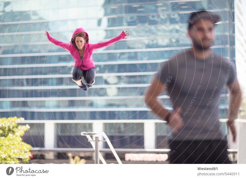 Man running and woman jumping in the city Leaping exercising exercise training practising athlete Sportspeople Sportsman Sportsperson athletes Sportsmen jumps