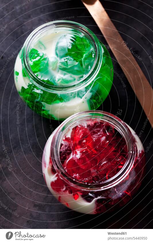 Red and green woodruff jelly in a glass with vanilla sauce close-up close up closeups close ups close-ups ready to eat ready-to-eat red currant jelly