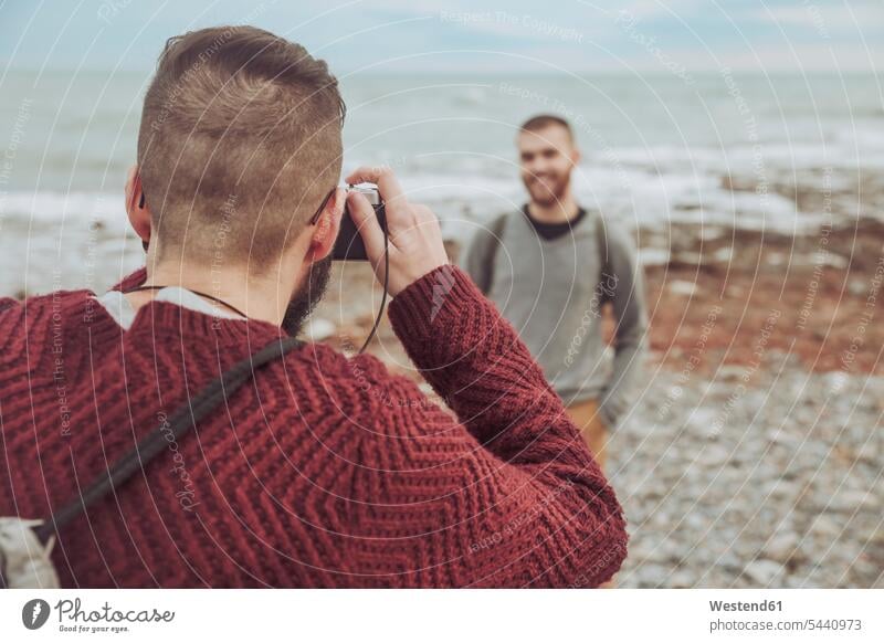 Man taking photos of his boyfriend in front of the sea beach beaches photographing homosexual queer same-sex homosexually gay Sea ocean man men males camera