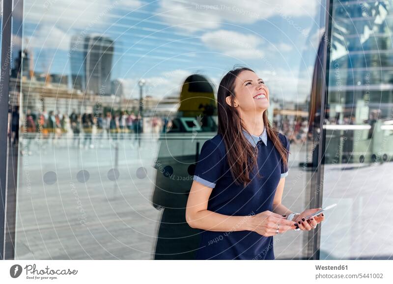 UK, London, happy woman with smartphone in the city females women mobile phone mobiles mobile phones Cellphone cell phone cell phones smiling smile Adults