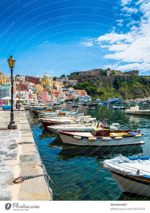 Italy, Campania, Gulf of Naples, Phlegraean Islands, Procida Island, Harbour, Marina di Corricella, former prison on mountain waterfront promenade Travel moored