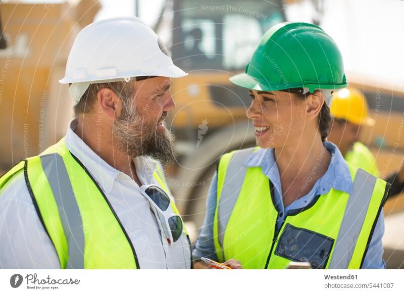 Male and female quarry workers discussing on site discussion mining blue collar worker blue-collar worker working At Work gravel pit open-pit mining
