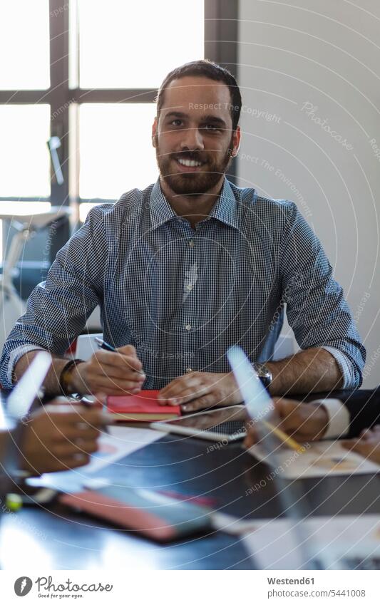 Portrait of smiling businessman during a meeting in office offices office room office rooms workplace work place place of work smile Business Meeting