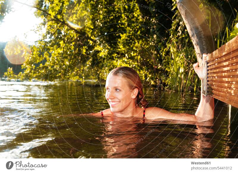 Happy young woman in a lake females women happiness happy lakes swimming Adults grown-ups grownups adult people persons human being humans human beings water