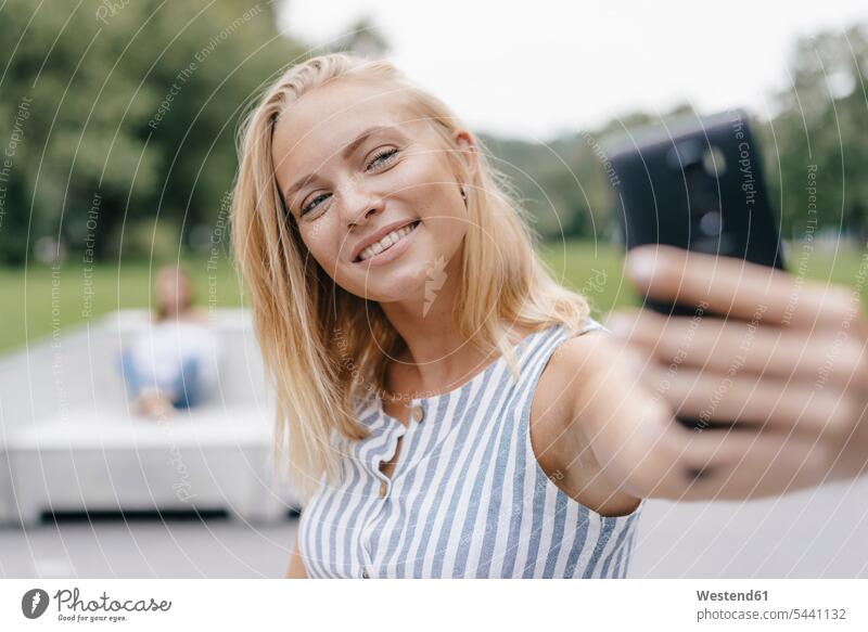 Portrait of smiling young woman taking a selfie in a skatepark Skateboard Park skate park smile females women portrait portraits mobile phone mobiles
