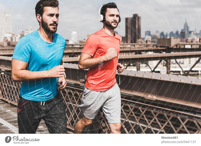 USA, New York City, two men running on Brooklyn Brige Jogging man males bridge bridges headphones headset fitness sport sports Adults grown-ups grownups adult
