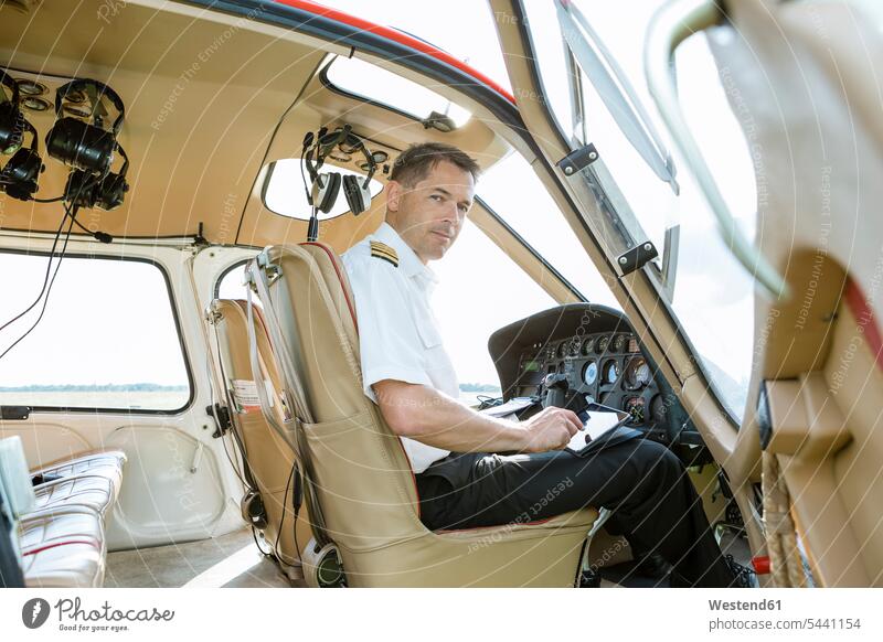 Portrait of pilot in cockpit of a helicopter pilots aircraft Air Vehicle aircrafts Air Vehicles transportation portrait portraits man men males tablet digitizer