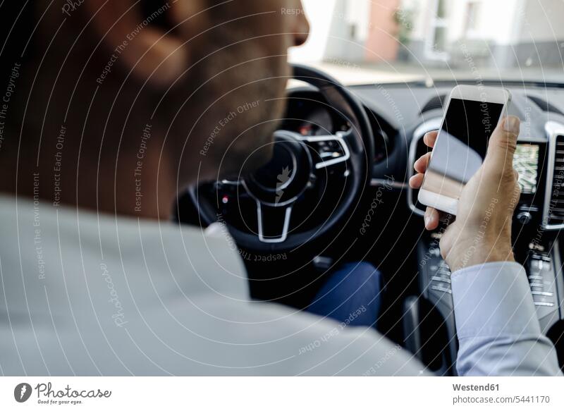 Businessman driving car looking at cell phone automobile Auto cars motorcars Automobiles Business man Businessmen Business men drive mobile phone mobile phones