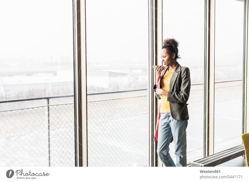 Young woman standing at window using smart phone confidence confident on the phone call telephoning On The Telephone calling mobile phone mobiles mobile phones