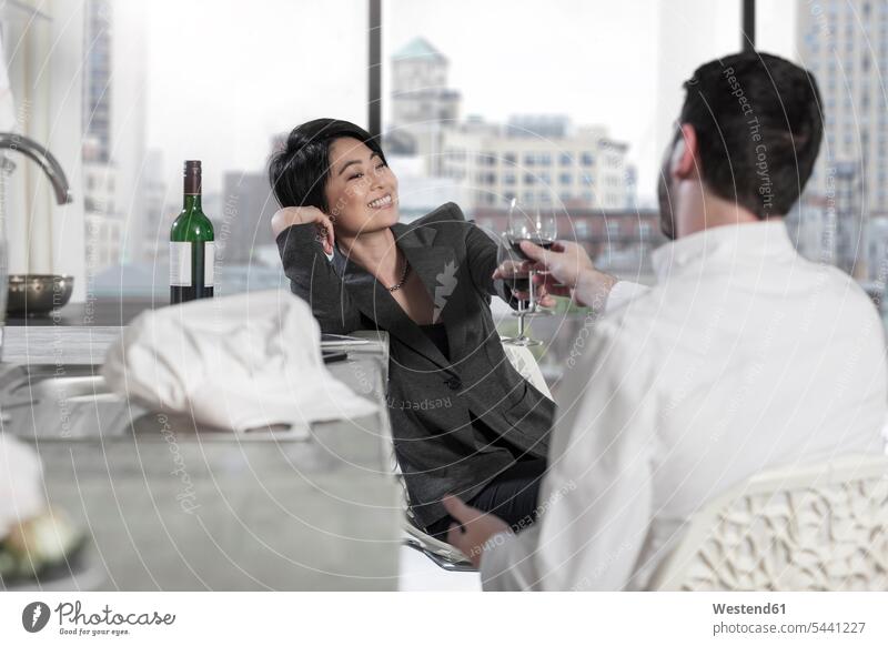 Couple raising a toast in open plan apartment with city view home at home couple twosomes partnership couples people persons human being humans human beings