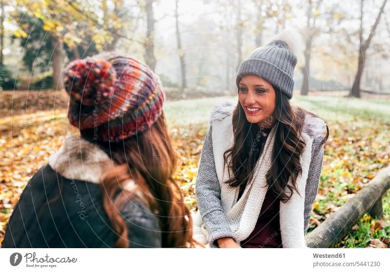 Two pretty women relaxing in an autumnal forest fall relaxed relaxation beautiful woods forests female friends woman females mate friendship Adults grown-ups