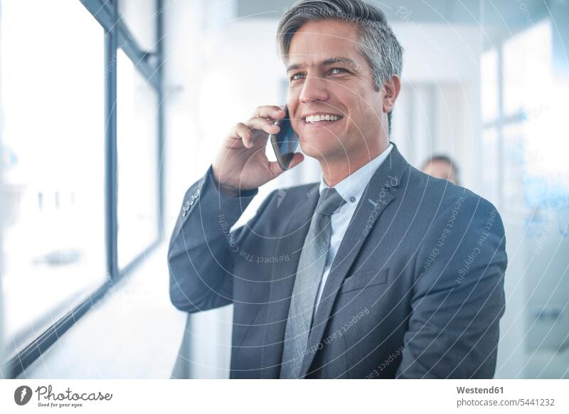 Businessman in office talking on the phone Office Offices Success successful friendly nice Smartphone iPhone Smartphones call telephoning On The Telephone