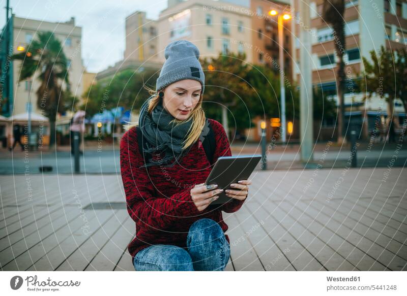 Spain, Barcelona, young woman using a tablet outside in winter females women digitizer Tablet Computer Tablet PC Tablet Computers iPad Digital Tablet
