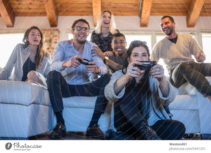 Friends playing computer game at home friends computer games games console game console Game Consol paddle friendship sitting Seated couch settee sofa sofas