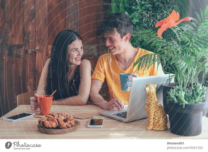 Young couple having coffee and chocolate braids using laptop at home breakfast twosomes partnership couples portrait portraits Laptop Computers laptops notebook