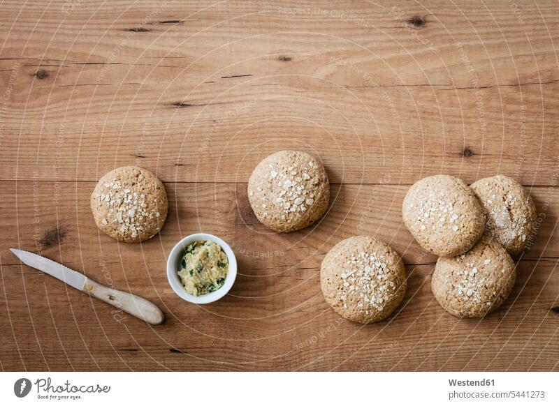 Homemade oat rolls with compound butter knife knives Oat Avena sativa Oats copy space wooden homemade home made home-made herb butter herbs Dipping Bowl