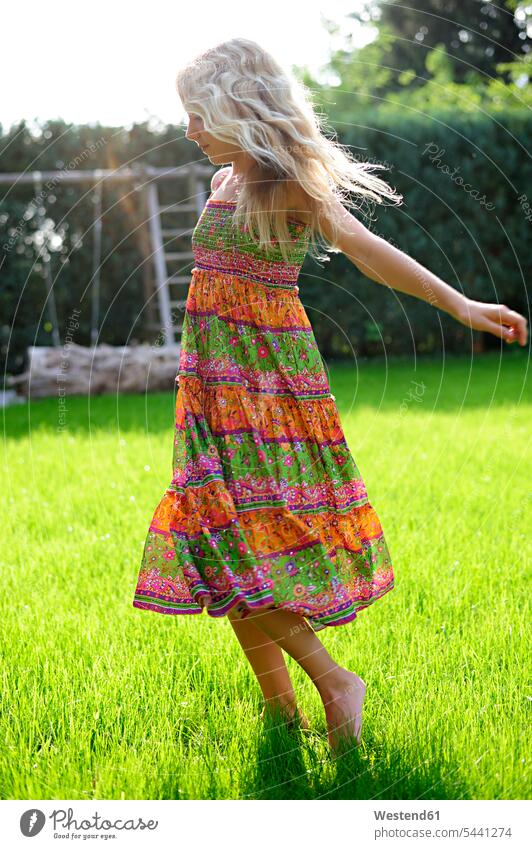 Girl wearing a dress playing in garden gardens domestic garden girl females girls dresses child children kid kids people persons human being humans human beings