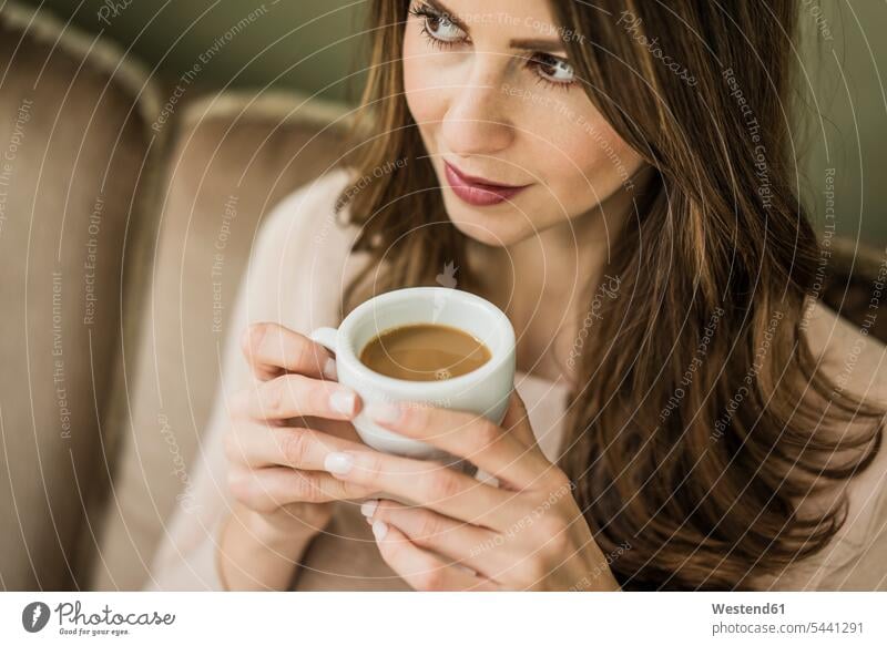 Portrait of woman sitting on couch drinking cup of white coffee females women Coffee Adults grown-ups grownups adult people persons human being humans