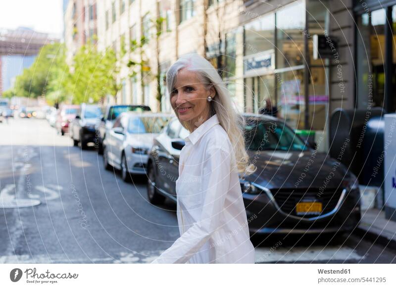 USA, Brooklyn, portrait of smiling mature woman crossing the street females women Adults grown-ups grownups adult people persons human being humans human beings