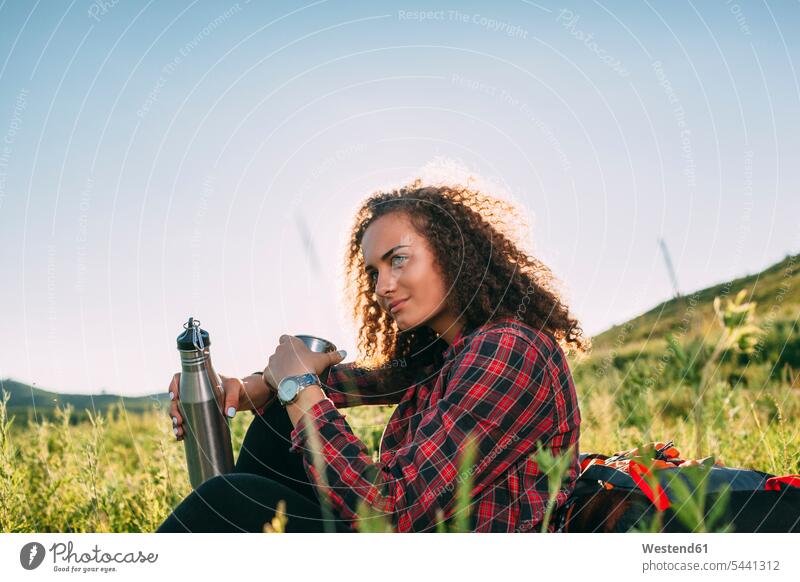 Teenage girl with thermos flask having a rest in nature Teenage Girls female teenagers portrait portraits Teenager Teens people persons human being humans