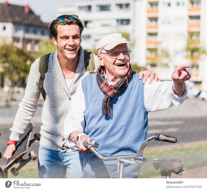 Happy senior man with adult grandson in the city on the move Fun having fun funny laughing Laughter happiness happy grandsons grandfather grandpas granddads