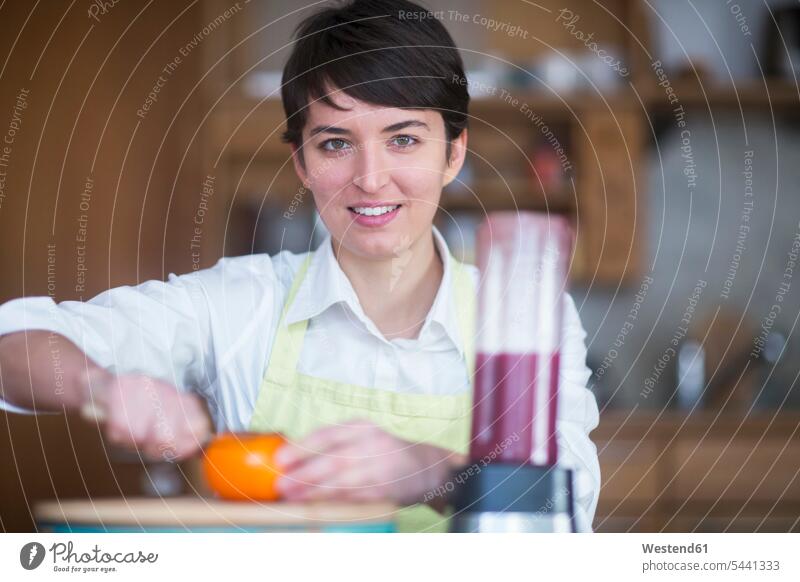 Portrait of young woman preparing healthy food in the kitchen females women portrait portraits Adults grown-ups grownups adult people persons human being humans