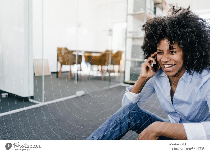 Laughing young woman on cell phone in office mobile phone mobiles mobile phones Cellphone cell phones laughing Laughter on the phone call telephoning