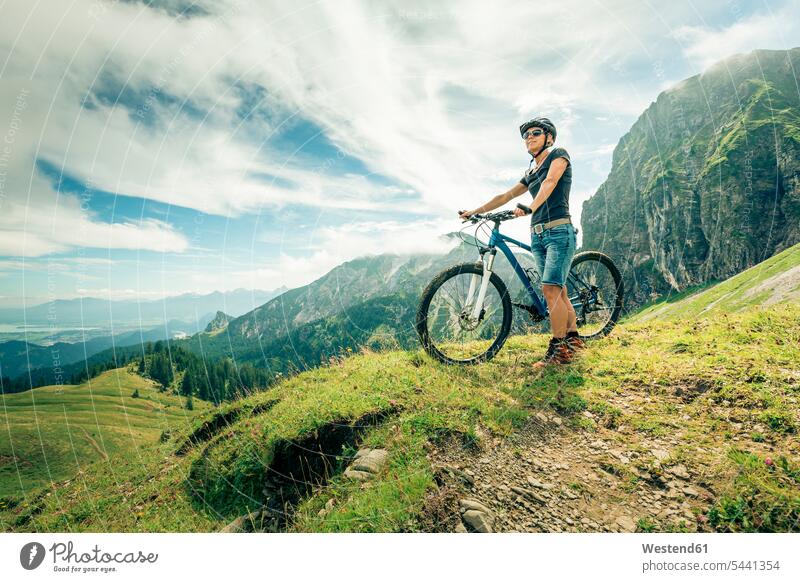 Germany, Bavaria, Pfronten, woman with mountain bike on alpine meadow near Aggenstein View Vista Look-Out outlook females women standing bicycle bikes bicycles