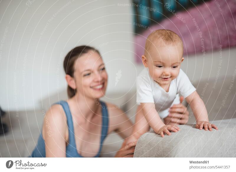 Happy baby girl with mother on couch smiling smile infants nurselings babies mommy mothers ma mummy mama people persons human being humans human beings parents