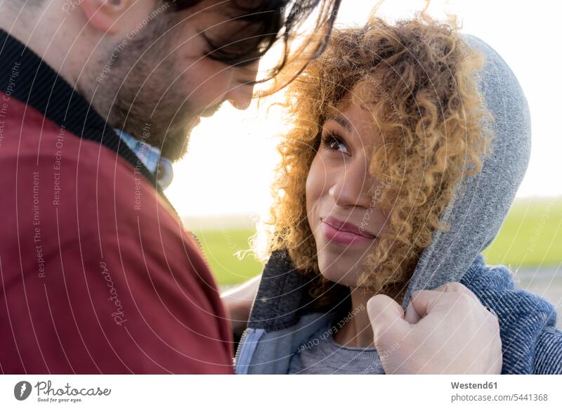 Portrait of smiling young couple close together outdoors portrait portraits twosomes partnership couples closeness propinquity smile people persons human being