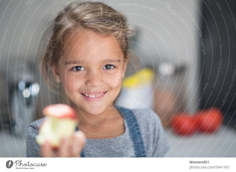 Portrait of smiling girl with apple in kitchen smile portrait portraits Apple Apples Fruit Fruits Food foods food and drink Nutrition Alimentation