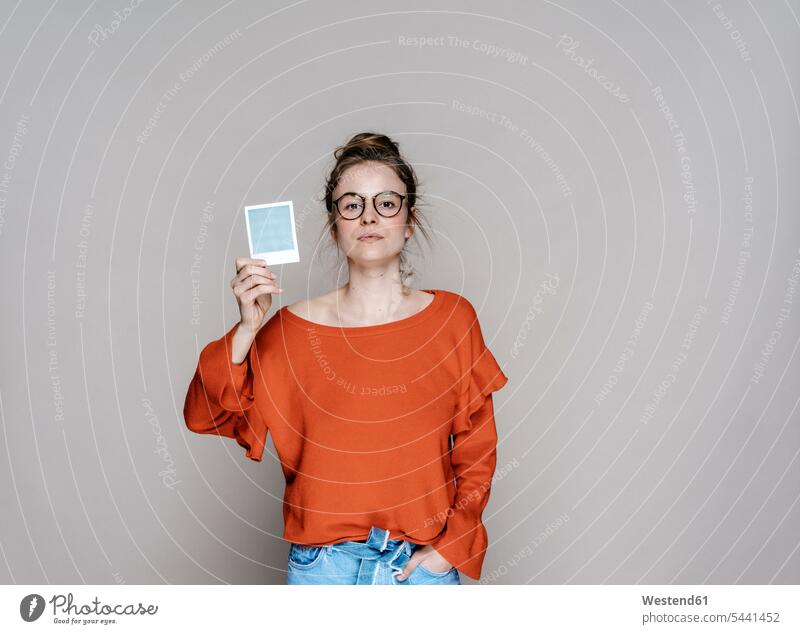 Portrait of young woman holding instant photo photograph photographs photos females women image images picture pictures Adults grown-ups grownups adult people