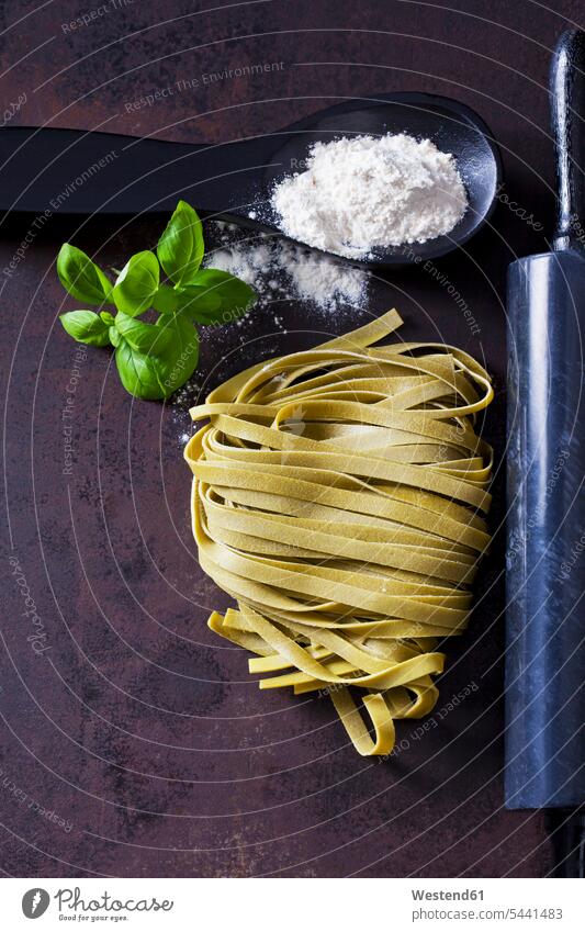 Green Tagliatelle, spoon of flour, basil leaves and rolling pin on rusty ground metal metals Flour Flours Green Noodles spoons rolling pins Pasta Ribbon Noodles